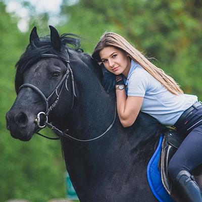 Kobieta siedząca na czarnym koniu